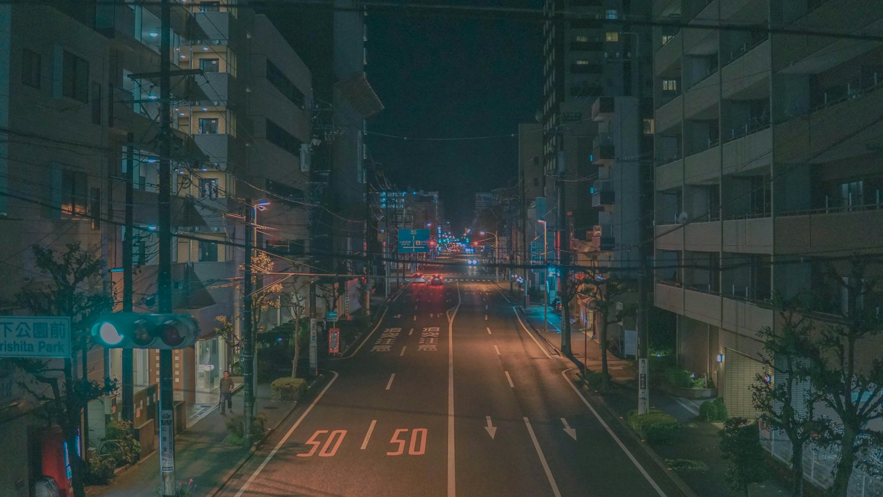 夜の街路。長時間露光で、通り過ぎた車の光が一本の筋になっている