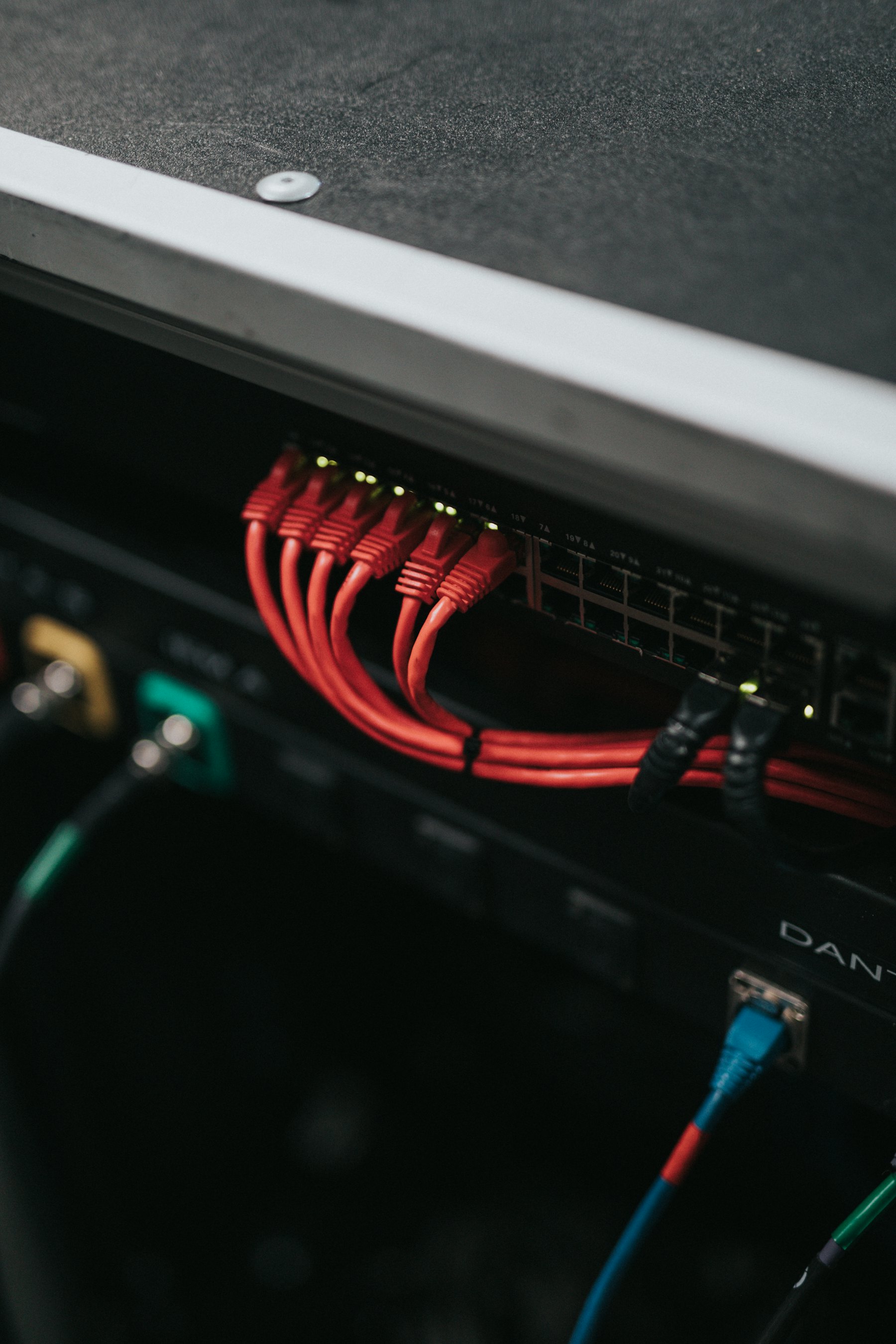ネットワーク機器の背面。赤いLANケーブルが等間隔で挿さっている